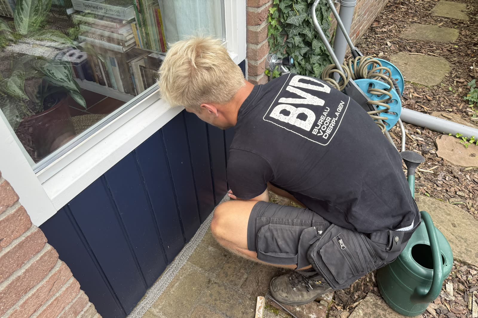 BVD-medewerker inspecteert de gevelvoet bij een raam