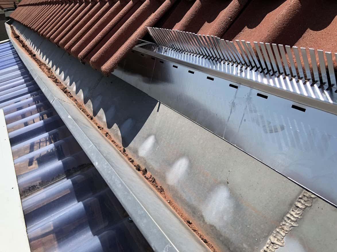 Metalen anti-marterprofielen geïnstalleerd op de rand van een dak om te voorkomen dat steenmarters toegang krijgen tot de woning.
